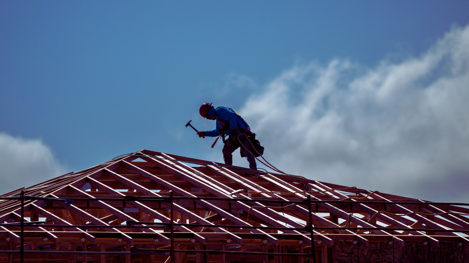 A worker on the roof of a new home under construction in California.